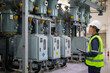 © JD Studio - Power station staff inspect electrical equipment in high voltage industrial facility ensuring safety and functionality with careful attention and professional expertise in clean environment