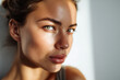 © EricMiguel - Close-up portrait of a young woman with clear skin and striking green eyes in natural sunlight