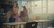 © Framestock - Female Teacher Finishing the Lesson, Announcing the End of School Day to Diverse Kids. Elementary School Students Standing Up, Packing Their Backpacks and Leaving Modern Classroom. Slow Motion.