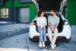 © Serhii - Young couple relaxing while charging electric car at home
