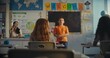© Framestock - STEM Class on Renewable Energy: Female Teacher Calling Elementary School Student to the Board. Talented Boy Presenting Homework on Ecology in Front of Classroom Full of Diverse Children, Classmates.