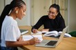 © Color Forge - Two Young Women Studying Together at Desk with Laptop and Books