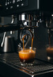 © Gustavo Alves - Close-up of a creamy espresso extraction from a professional coffee machine into two cups.