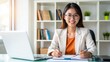 © Vision Grid - Portrait of smiling asian businesswoman working at desk with laptop in home office