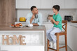 © Pixel-Shot - Cute little boy with his father drinking tea in kitchen