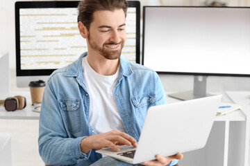 Wall Mural - male programmer with laptop at workplace in office