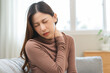 © KMPZZZ - Pain body muscles stiff problem, suffer asian young woman, girl painful with back, holding neck ache from work hand holding massaging rubbing shoulder hurt, sore sitting on couch at home. Health care