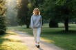 © ЮРИЙ ПОЗДНИКОВ - Woman walking in park enjoying sunlight during morning exercise
