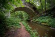 © Milan - Židova Strouha Stream in South Bohemia, Czech Republic – Summer Landscape with Rocks, Lush Vegetation and Stone Bridge