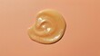 © PremiumPhoto - Snail mucin face cream. Swirling beige cream smear on peach background