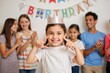 © WoodHunt - A birthday girl holds a crown, smiling and pointing at it. Behind her, friends are clapping and a banner says 'Happy Birthday