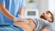 © Alena - Doctor performing abdominal examination on a male patient in a clinical setting. Close-up of physician’s hands palpating the stomach area for diagnostic assessment of internal organs and health