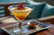 © whitestorm - Gourmet saffron cocktail in a martini glass on a decorative silver tray.
