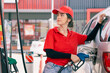 © Quality Stock Arts - Happy gas station staff worker latin women handle fuel nozzle for refill car fuel