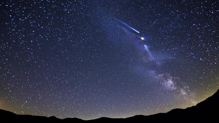 Wall Mural - a wide-angle video captures a starry night sky over silhouetted mountains, showcasing a serene and e