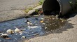 © YourAIStocker  - Urban storm drain overflow spilling polluted water and waste onto city street