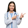 © Shahnaj - Smiling female doctor wearing a white lab coat and stethoscope pointing to the right isolated on transparent background