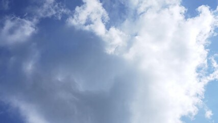 Wall Mural - Timelapse of fluffy clouds drifting across a sunny blue sky