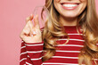 © ViDi Studio - Close up cropped young smiling woman wear red striped sweatshirt casual clothes hold in hand showing invisible transparent aligners, invisalign dental braces isolated on plain pink background studio.