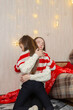 © Mariia - Christmas at home and daughter with mother hugs in the living room.