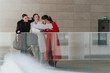 © qunica.com - Three female entrepreneurs standing in a modern office space, collaboratively reviewing documents and planning for business strategies, portraying teamwork and professional engagement.