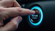 © Oran - Hand pressing futuristic start button in vehicle, symbolizing innovation and technology. button glows blue, indicating activation