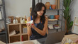 © Krakenimages.com - Woman in denim apron holds white clay bowl in studio surrounded by pottery shelves and tools; creative focus.