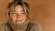 © tri - Close-up of a woman with blonde hair and a beige sweater, gazing upward with a happy expression
