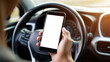 © Kaylash - Hand holding phone inside car near steering wheel smartphone
