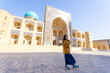 © LT - woman as a tourist have fun in front of Poi-Kalyan Kalyan mosque in bukhara Uzbekistan