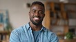 © Johannes - Smiling cheerful young adult african american ethnicity man looking at camera standing at home office background. Happy confident black guy posing for headshot face front close up portrait., no logos