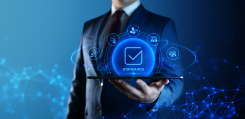 Wall Mural - businessman holding tablet with standards icons on screen. quality management concept