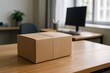 © Olga Ко - Cardboard unopened package on office desk – parcel delivery concept