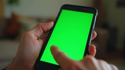 Close-up of person using smartphone with green screen for digital overlay, mockup usage
