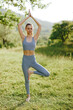 © SHOTPRIME STUDIO - Young woman practicing yoga in a serene outdoor setting, wearing a light blue sports outfit, showcasing a balanced pose surrounded by nature