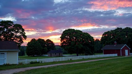 Wall Mural - sunset over a farm with a white fence and a red barn