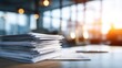 © Almarkha3 - High stack of papers on a desk in a sunlit office