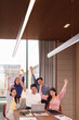 © Pichsakul - Young adult Asian business team celebrates project success collaboration triumph at modern office meeting room
