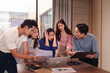 © Pichsakul - Asian business professionals confronting project challenges discussing issues collaborating workspace serious discussion stressful meeting office environment group problem solving