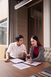 © Pichsakul - Asian adult business colleagues discuss project details analyze data digital information professional office environment