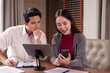 © Pichsakul - Asian adult business professionals collaborate review data using tablet smartphone documents modern office meeting room strategy project analysis development growth
