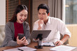 © Pichsakul - Asian adult business professionals collaboratively analyze data discuss innovative strategies utilizing tablet smartphone technology for corporate growth in modern office settings