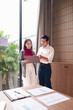 © Pichsakul - Asian business professionals review data documents collaborate discuss strategy modern office meeting room