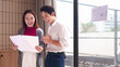 © Pichsakul - Asian business colleagues smiling discussing financial data reports in modern office workspace collaborative teamwork successful project review