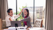 © Pichsakul - Asian Business Professionals Celebrating Project Success High Five Achievement Productive Teamwork Office Meeting Collaboration Adult Workers