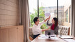 © Pichsakul - Asian business professionals high fiving celebrating success teamwork collaboration office meeting achievement corporate partnership strategy development growth