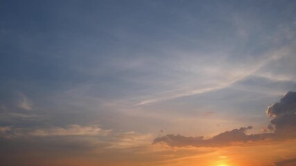 Wall Mural - a timelapse video shows a vivid sunset sky with warm orange and pink hues spreading softly across th