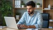 © Valentina - Attractive young Arab businessman using laptop pc at his desk in home office