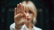 © Ketanoff - In a calm indoor environment, a woman raises her hand to signal stop as she addresses harassment, visibly expressing defiance and courage against inappropriate behavior