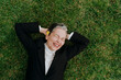 © Westend61 - Businesswoman in suit relaxing and laughing on grass outdoors